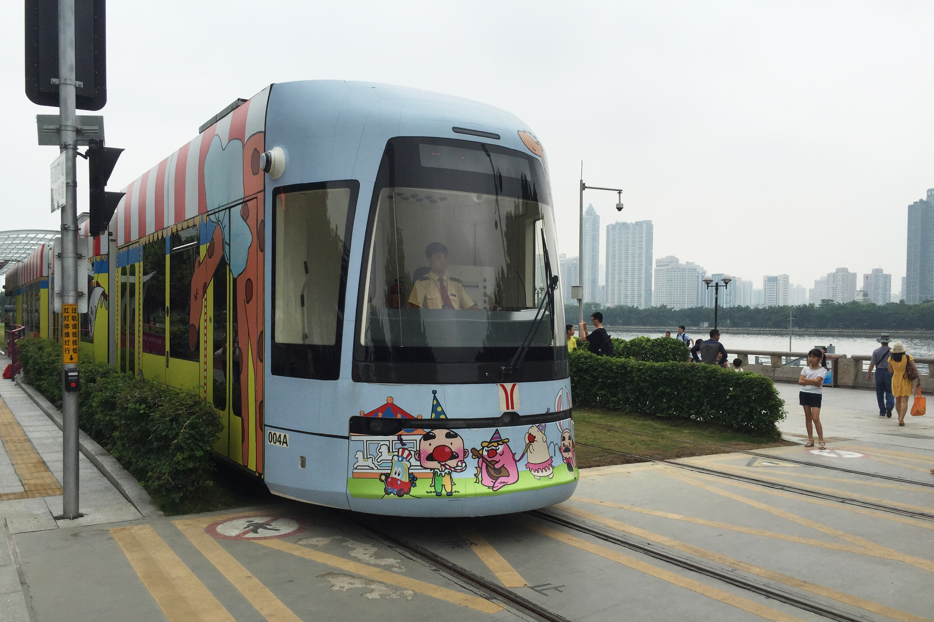 A circus-themed streetcar approaches a pedestrian crosswalk in Guangzhou, China. (NPR)