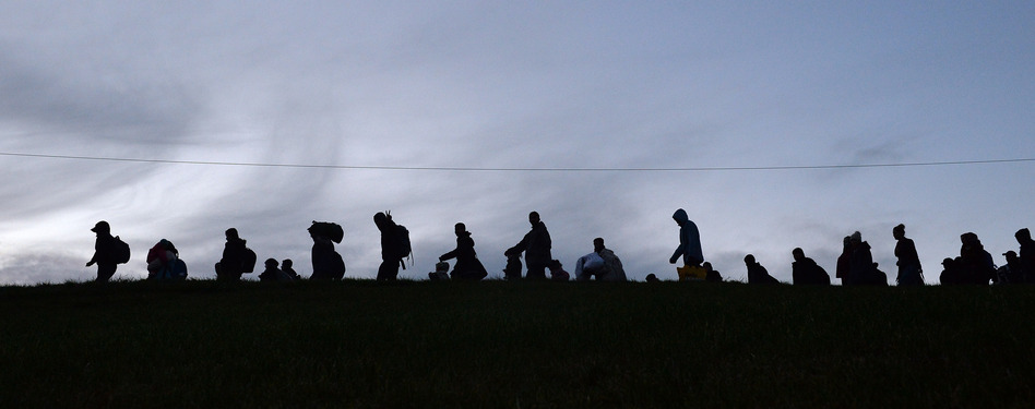 German police guide a group of migrants after they crossed the border between Austria and Germany near Passau, Germany, on Wednesday. The massive influx of migrants this year has stirred debate about Europe's open borders policy. (Kerstin Joensson/AP)