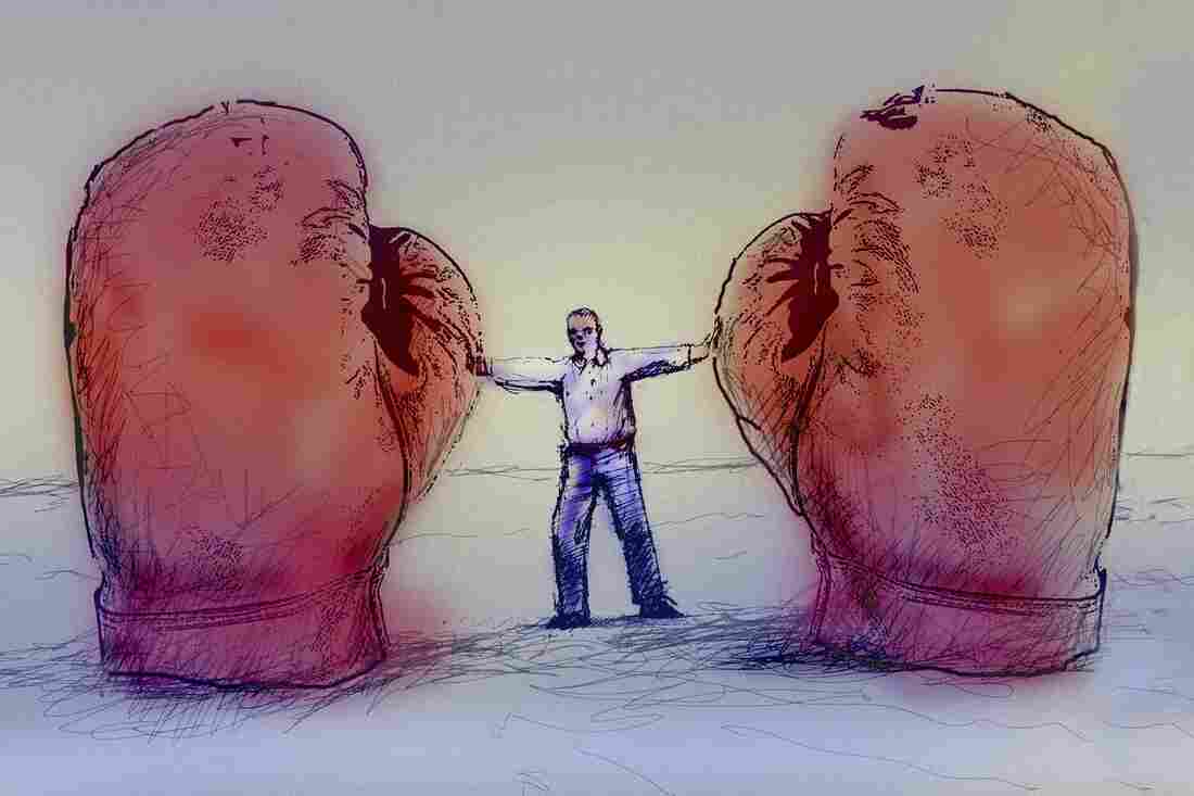 Man holding two large boxing gloves apart