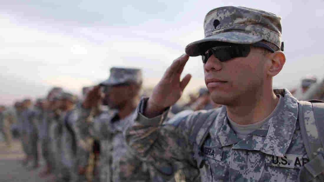 KUWAIT CITY, KUWAIT - DECEMBER 15: U.S. Army soldiers from the 2-82 Field Artillery, 3rd Brigade, 1st Cavalry Division, salute during the playing of retreat at the daily flag lowering ceremony as they prepare to fly home to Fort Hood, Texas; one of the last American combat units to exit from Iraq on December 15, 2011. The U.S. military formally ended its mission in Iraq after eight years of war.