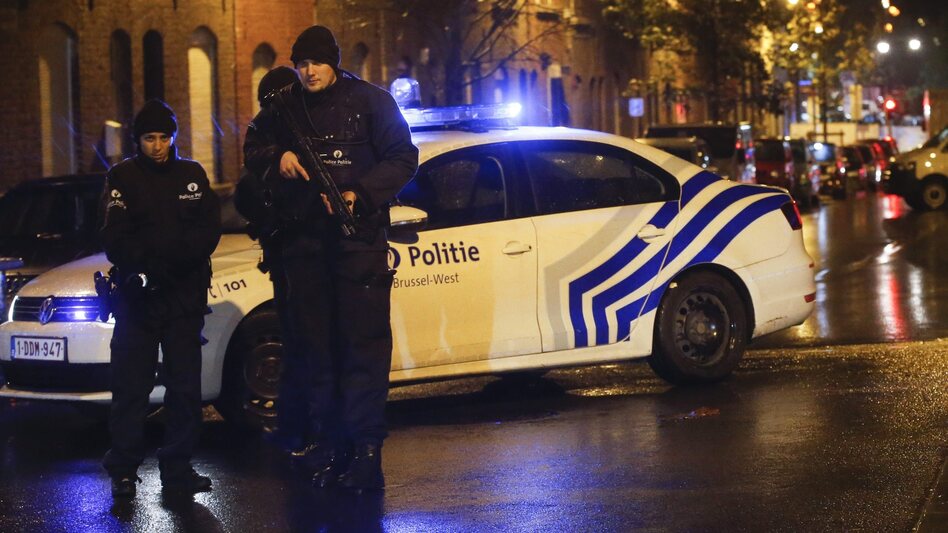 Police officers investigate the scene in the streets of Molenbeek, Brussels, Belgium, on Saturday. Officials say a man has been arrested in in connection with the terrorist attacks in Paris. (Olivier Hoslet /Landov)