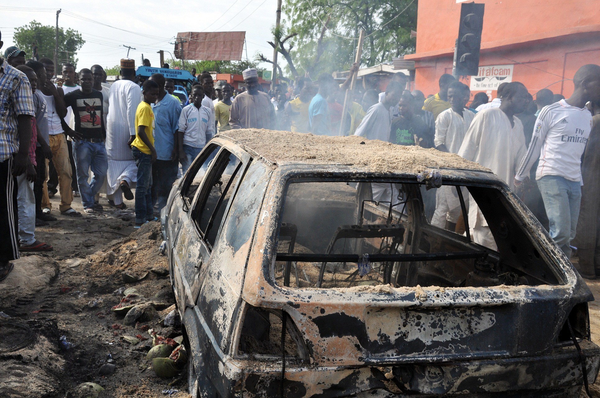 People gather to look at a burnt car following a bomb explosion that rocked a roundabout near the crowded Monday Market in Maiduguri, Nigeria, on July 1, 2014. The city has been repeatedly hit by Boko Haram terrorists. A recent report found that in 2014, the group was responsible for more known deaths from terrorism than any other organization.