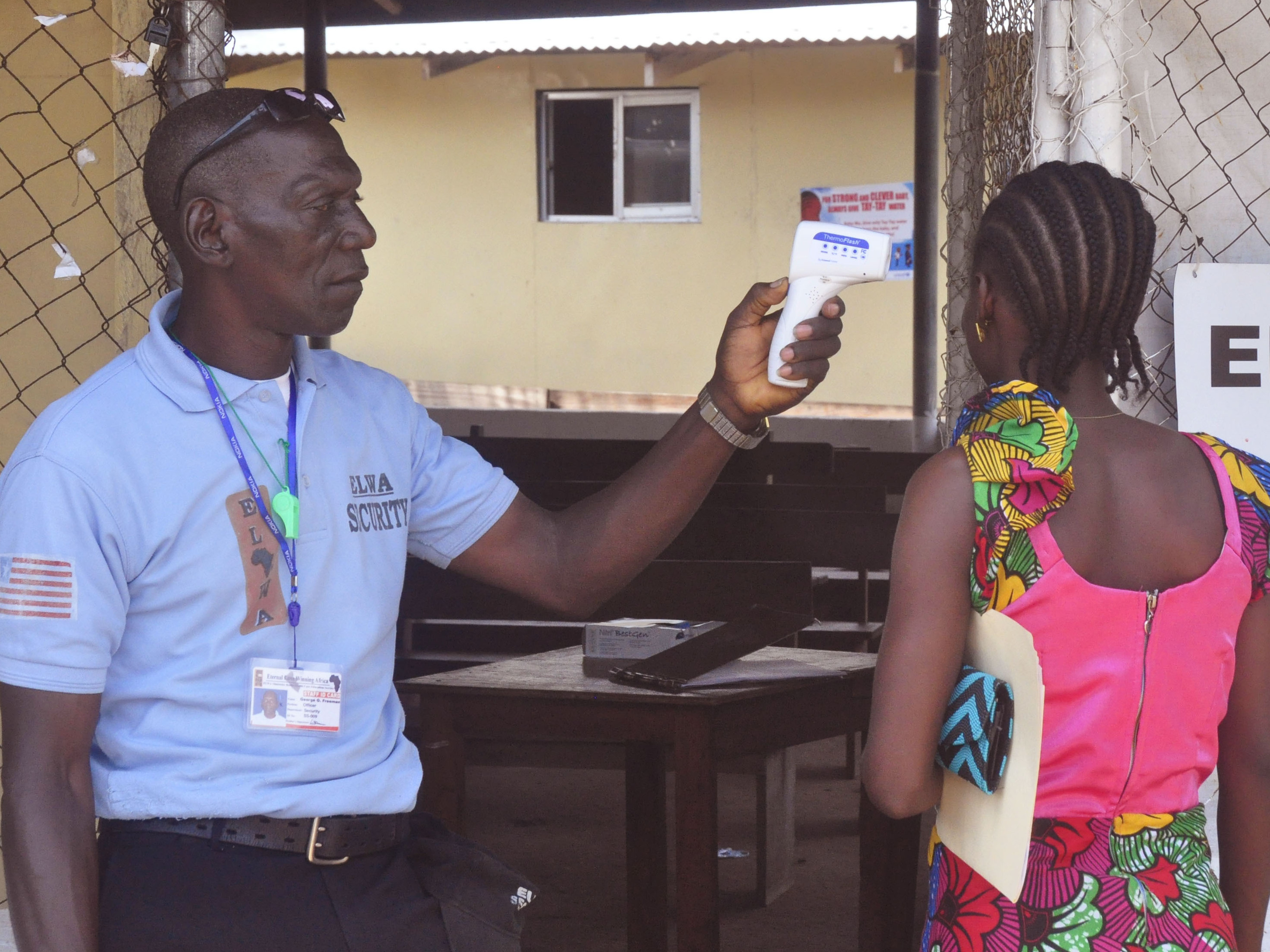 A relative of a boy who tested positive for Ebola in Liberia last week gets her temperature taken as she enters the clinic where he was being treated.