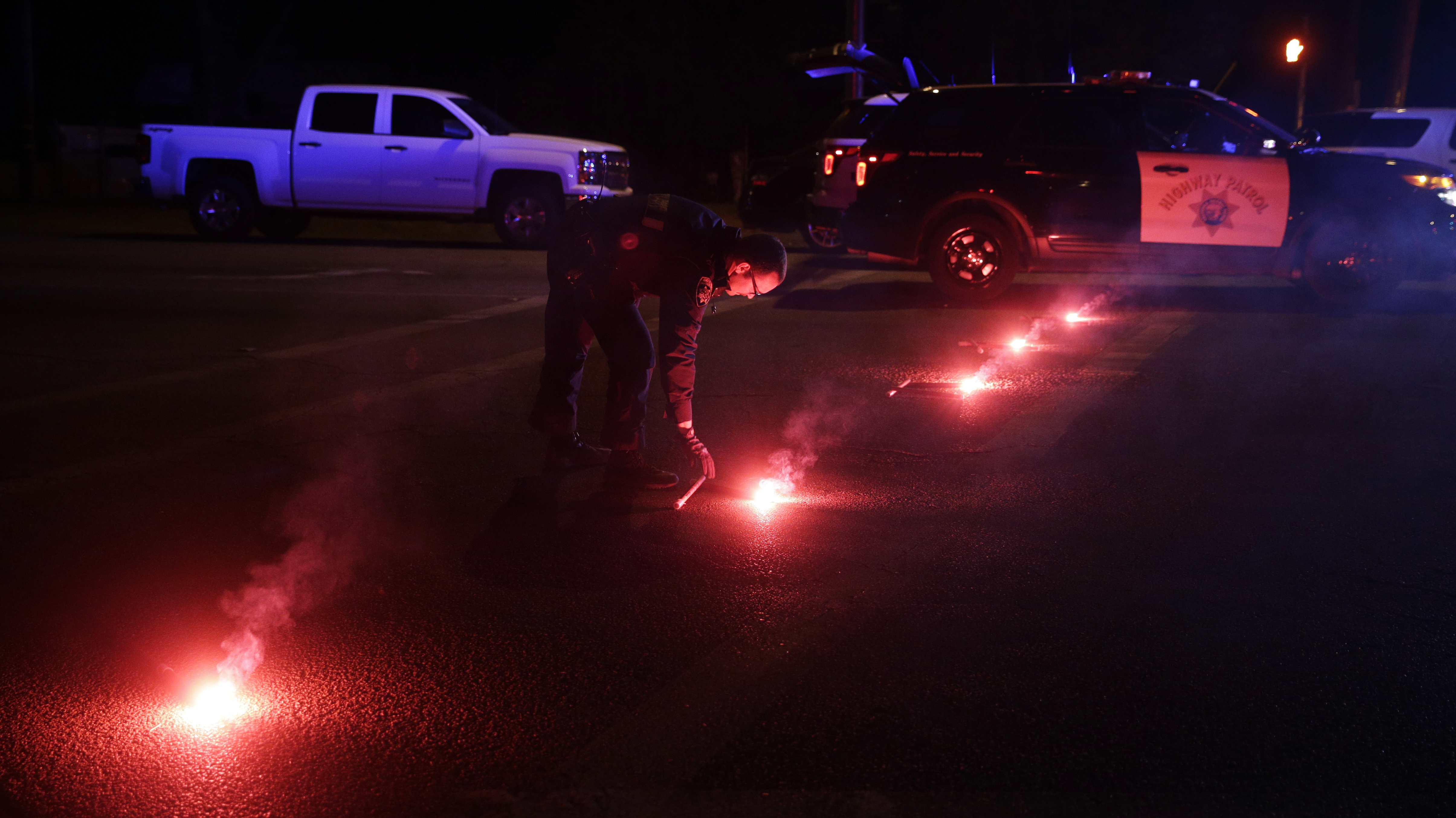 A police officer lights up flares near the scene of a shootout in San Bernardino, Calif., on Wednesday. Police say Syed Farook, 28, and Tashfeen Malik, 27, opened fire on an office holiday party in the Inland Regional Center.