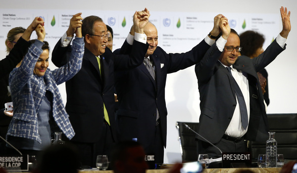 French President Francois Hollande, right, French Foreign Minister and president of the COP21 meetings Laurent Fabius, second right, UN climate chief Christiana Figueres, left, and UN Secretary-General Ban ki-Moon join hands after the final adoption of an agreement at the COP21 United Nations conference on climate change.