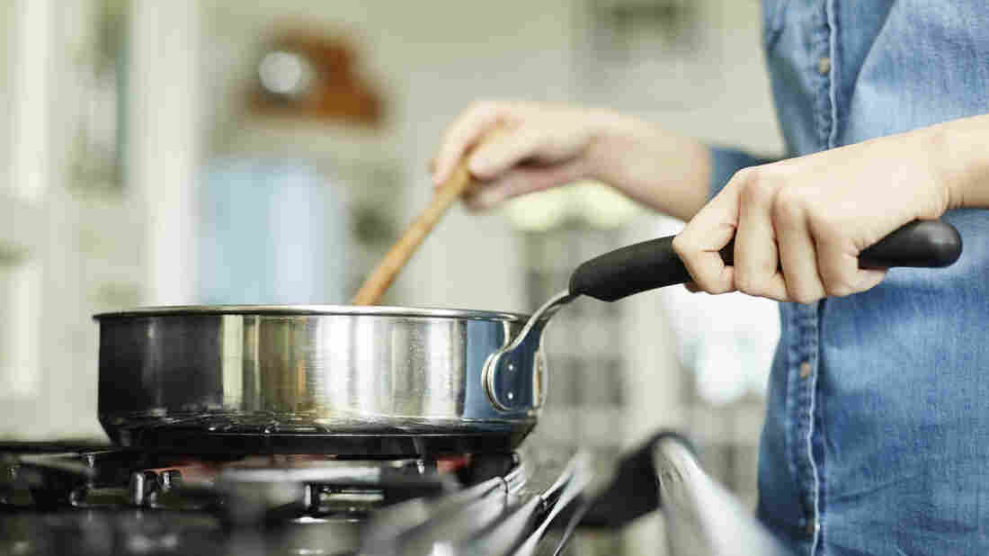 A woman cooks in her kitchen.