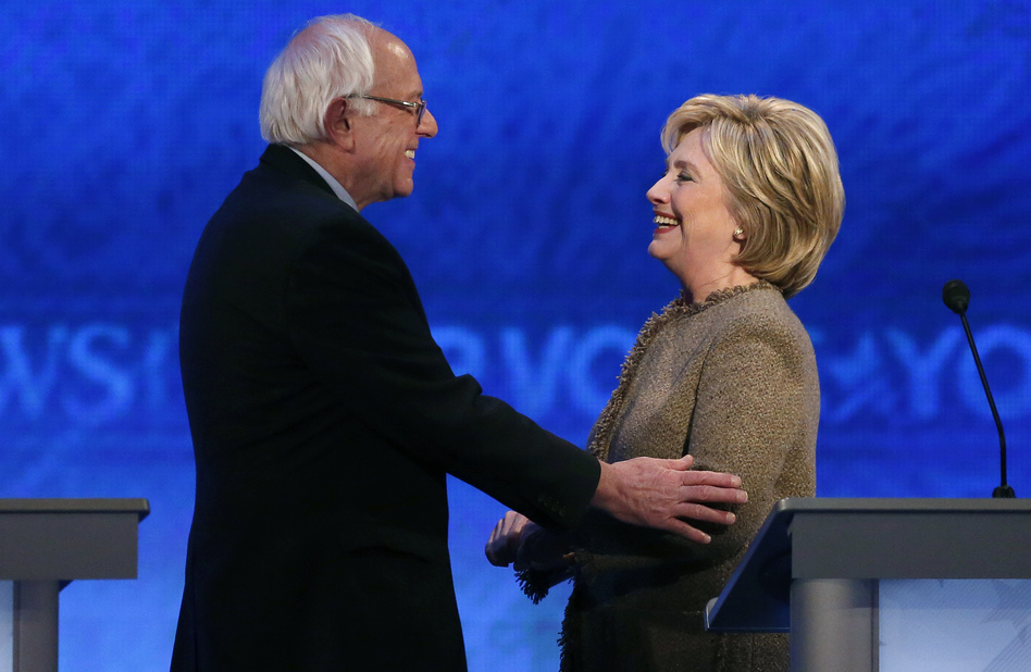 Bernie Sanders speaks with Hillary Clinton during a break at the third Democratic presidential debate Saturday night at Saint Anselm College in Manchester, N.H. (Jim Cole/AP)