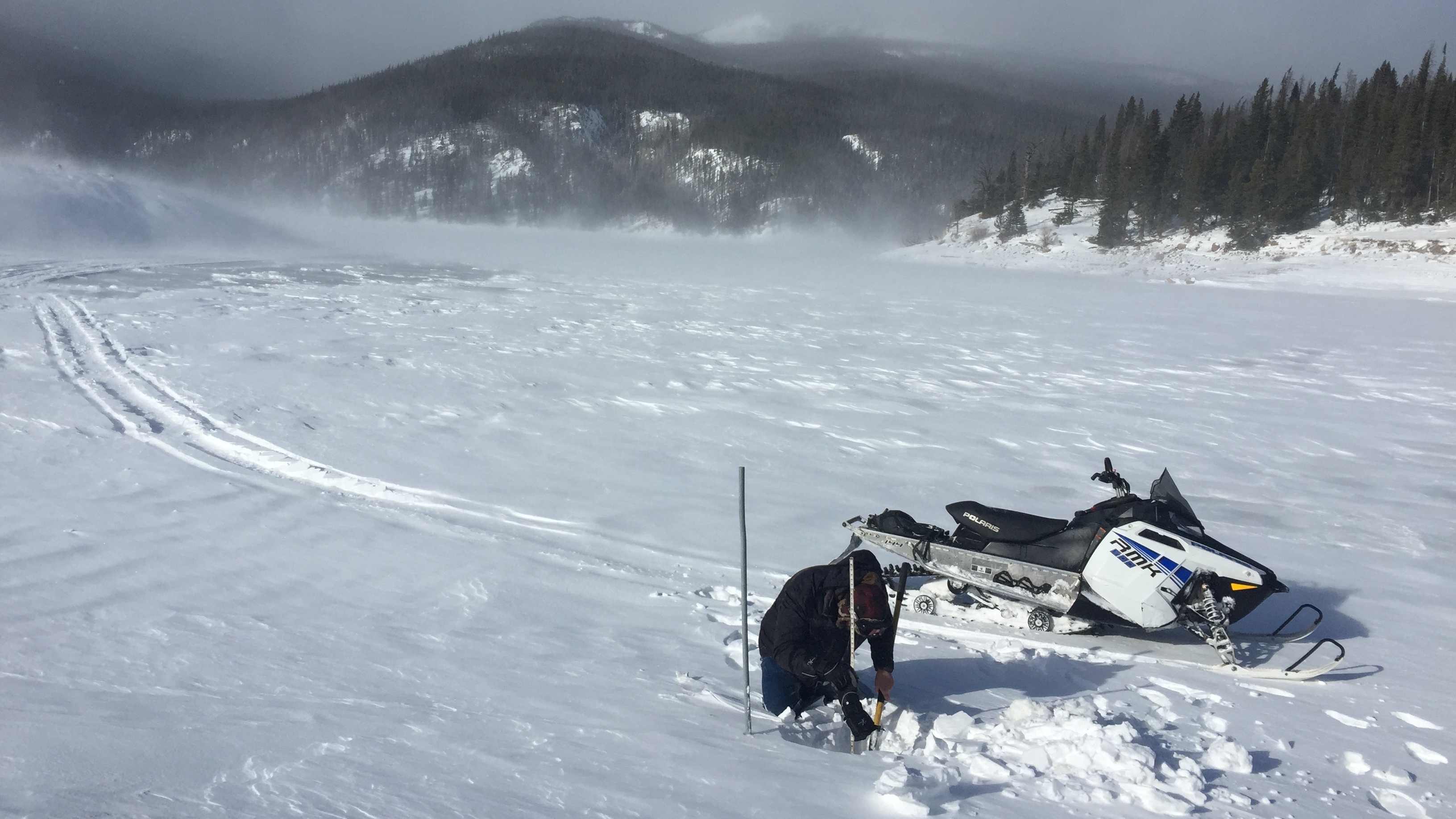 Reservoir caretaker Doug Billingsley tests water levels at windswept Chambers Lake near Cameron Pass, Colo.