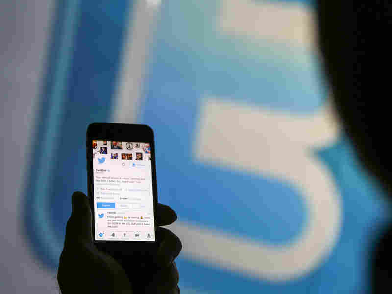 A man looks at the Twitter page on a smartphone.
