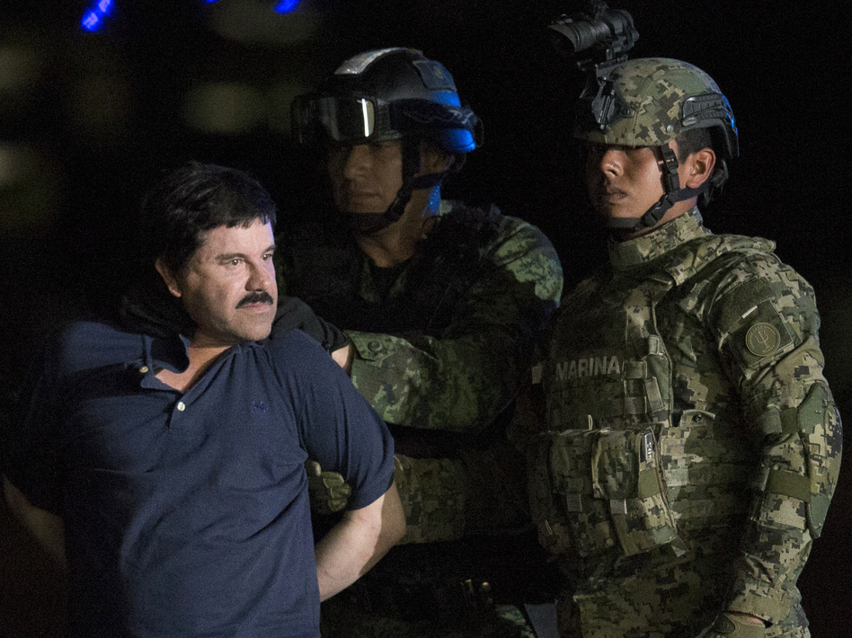 Mexican drug kingpin Joaquin "El Chapo" Guzman, escorted by army soldiers to a waiting helicopter, at a federal hangar in Mexico City on Friday. (Rebecca Blackwell/AP)