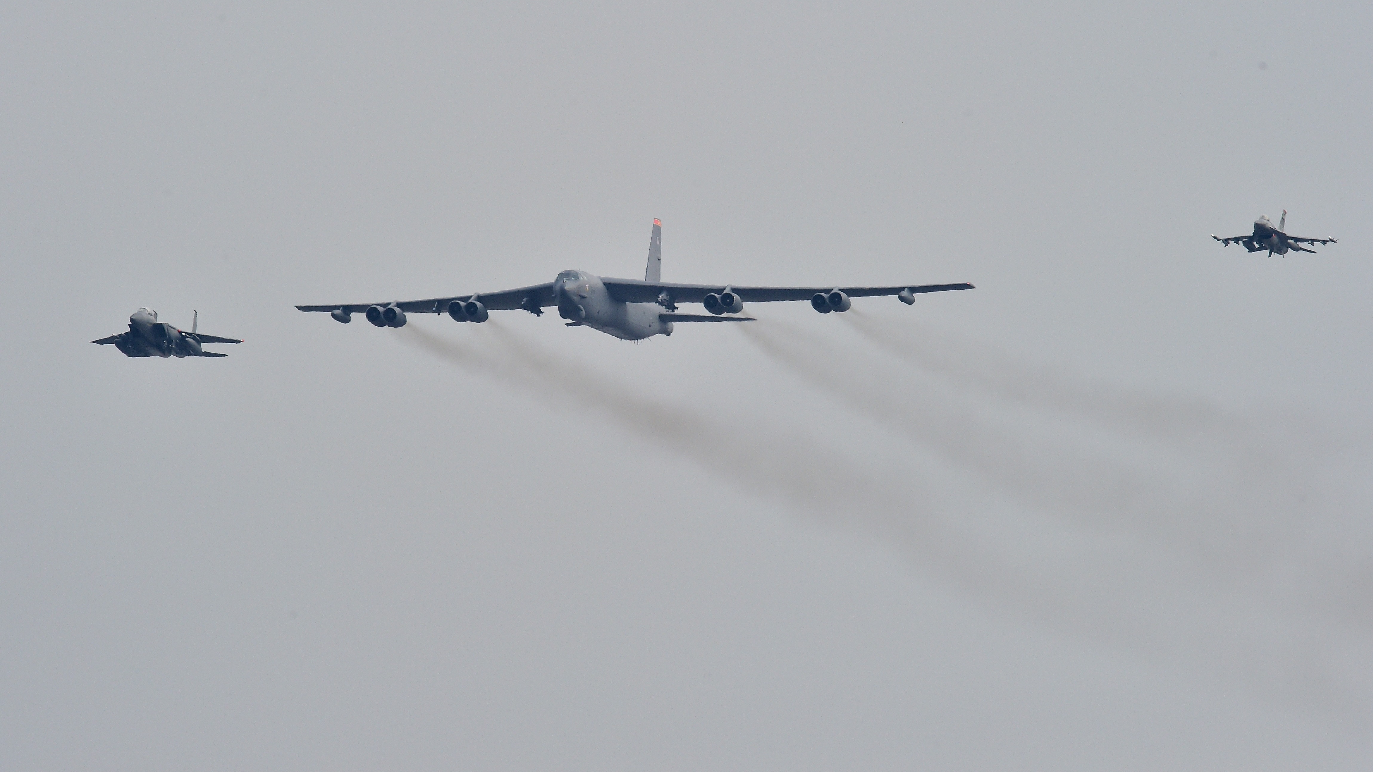 A US B-52 Stratofortress is escorted by a South Korean fighter jet (left) and a U.S. fighter jet (right) as it flies over the Osan Air Base in Pyeongtaek, south of Seoul, on Sunday. (AFP/Getty Images)