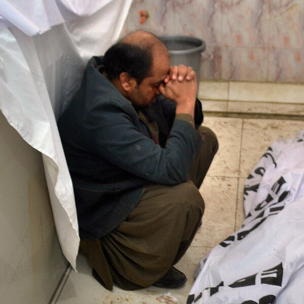 A Pakistani mourner sits alongside bodies of blast victims following a bombing near a polio vaccination center at a hospital in Quetta.