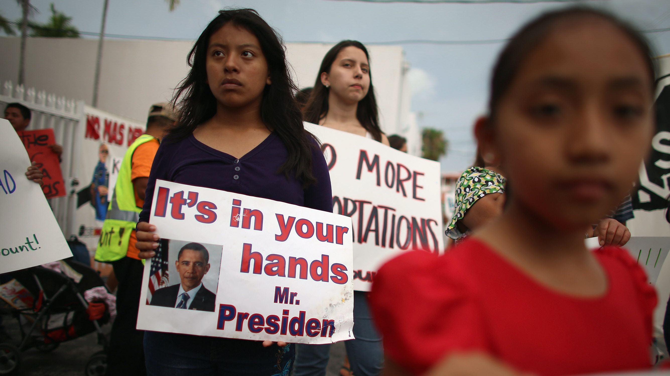 A young immigration activist holds a sign reading &quot;It's in your hands Mr. President&quot; during a rally calling on President Obama to suspend deportations in 2013. (Getty Images)
