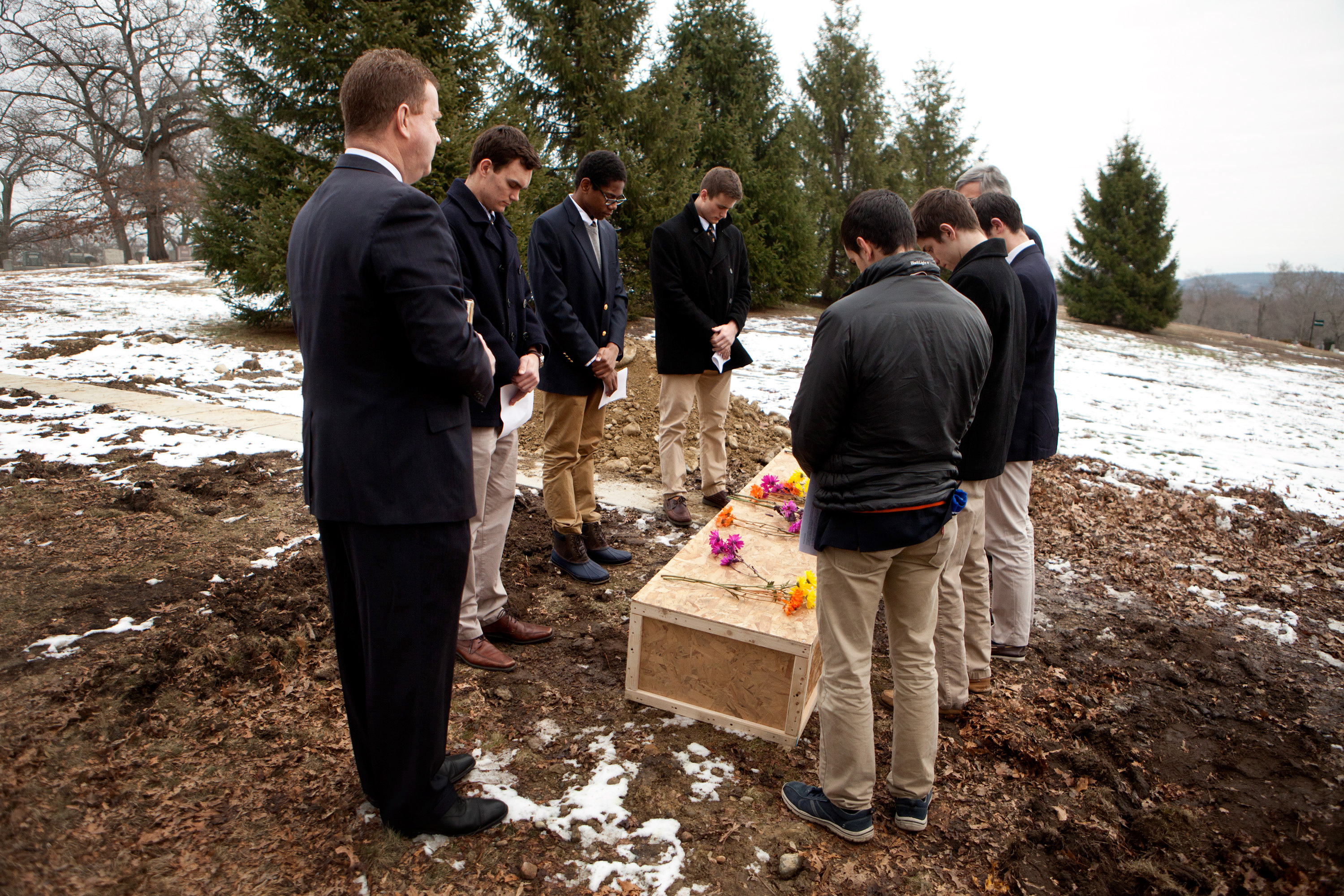 From left to right, funeral director Rob Lawler; Roxbury Latin students Emmett Dalton, Noah Piou and Chris Rota; Roxbury Latin assistant headmaster Mike Pojman, and Roxbury Latin students Brendan McInerney, Liam McDonough and Esteban Enrique conduct a graveside prayer service for Nicholas Miller on Friday at the Fairview Cemetery.