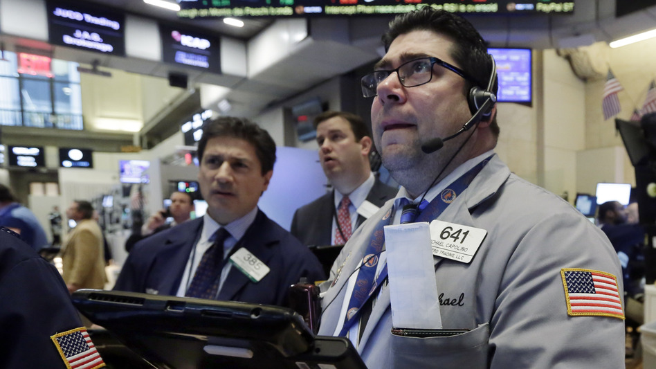 Trader Michael Capolino (right) watches prices on the floor of the New York Stock Exchange Wednesday. Stocks endured another bloodbath, and oil fell below $27 a barrel. (Richard Drew/AP)