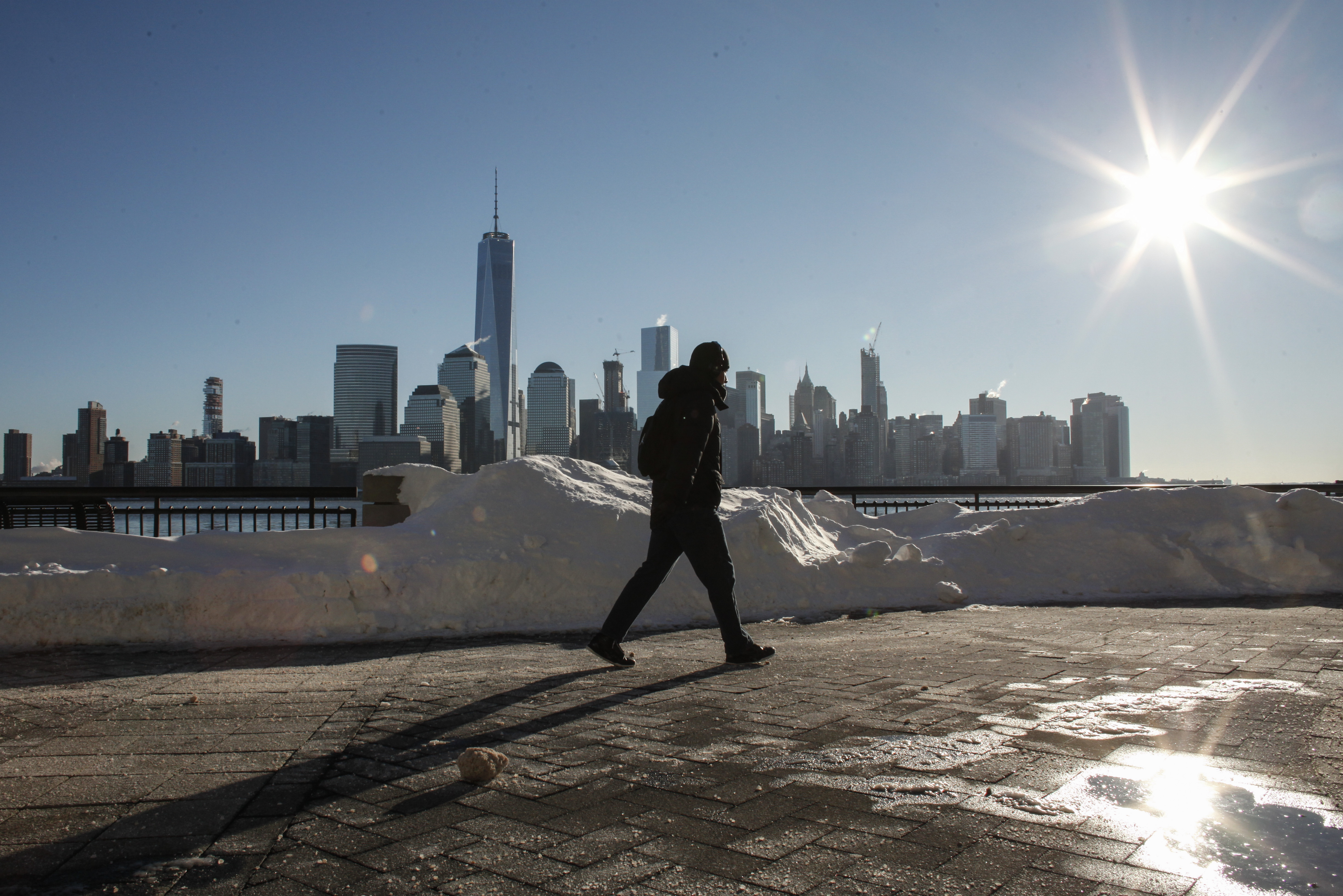 A man walks by the Hudson River Shore in Jersey City, with the New York City skyline behind him, on Sunday. A massive winter storm that lasted a day and a half finally appeared to be winding down Sunday, giving snowbound residents the chance to begin removing — and enjoying — the snow. (AFP/Getty Images)