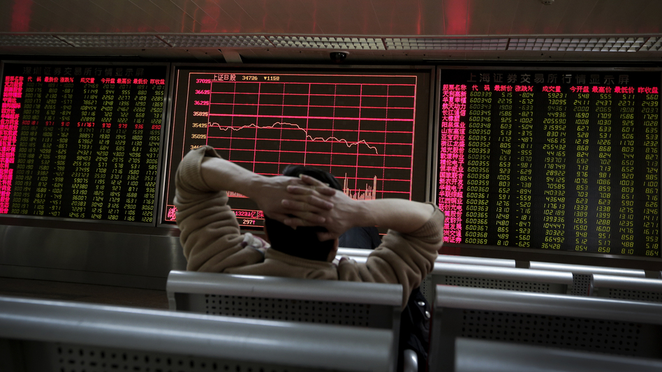 A man looks at an electronic stock board at a brokerage house in Beijing on Tuesday, a day in which Asian stock markets sank. (Andy Wong/AP)