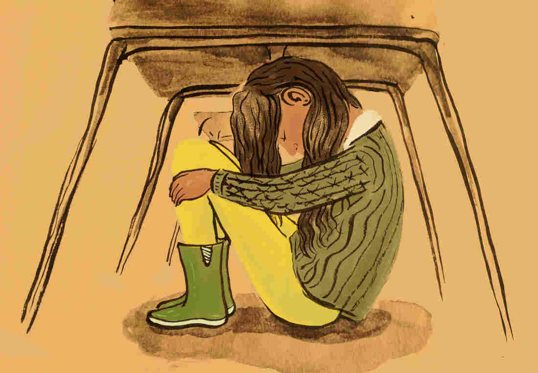 Student hiding under a desk