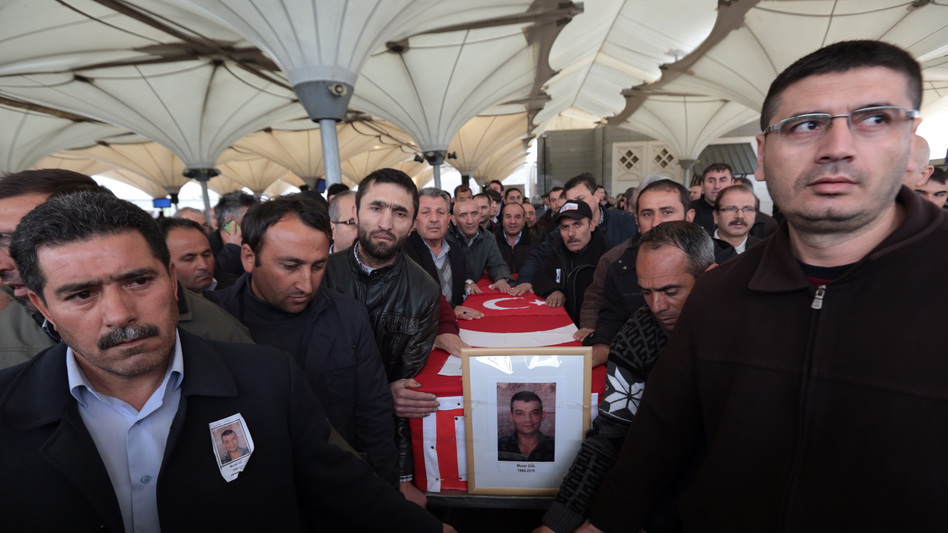 Family members and friends carry the Turkish flag-draped coffin of Murat Gul, 20, a security agent killed in Sunday's explosion, during his funeral procession in Ankara, Turkey. (Burhan Ozbilici/AP)