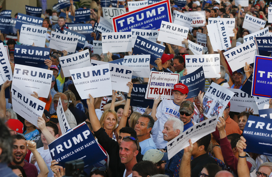 Audience members hold up signs supporting Republican presidential candidate Donald Trump during a campaign rally in Boca Raton, Fla., on Sunday. (Paul Sancya/AP)