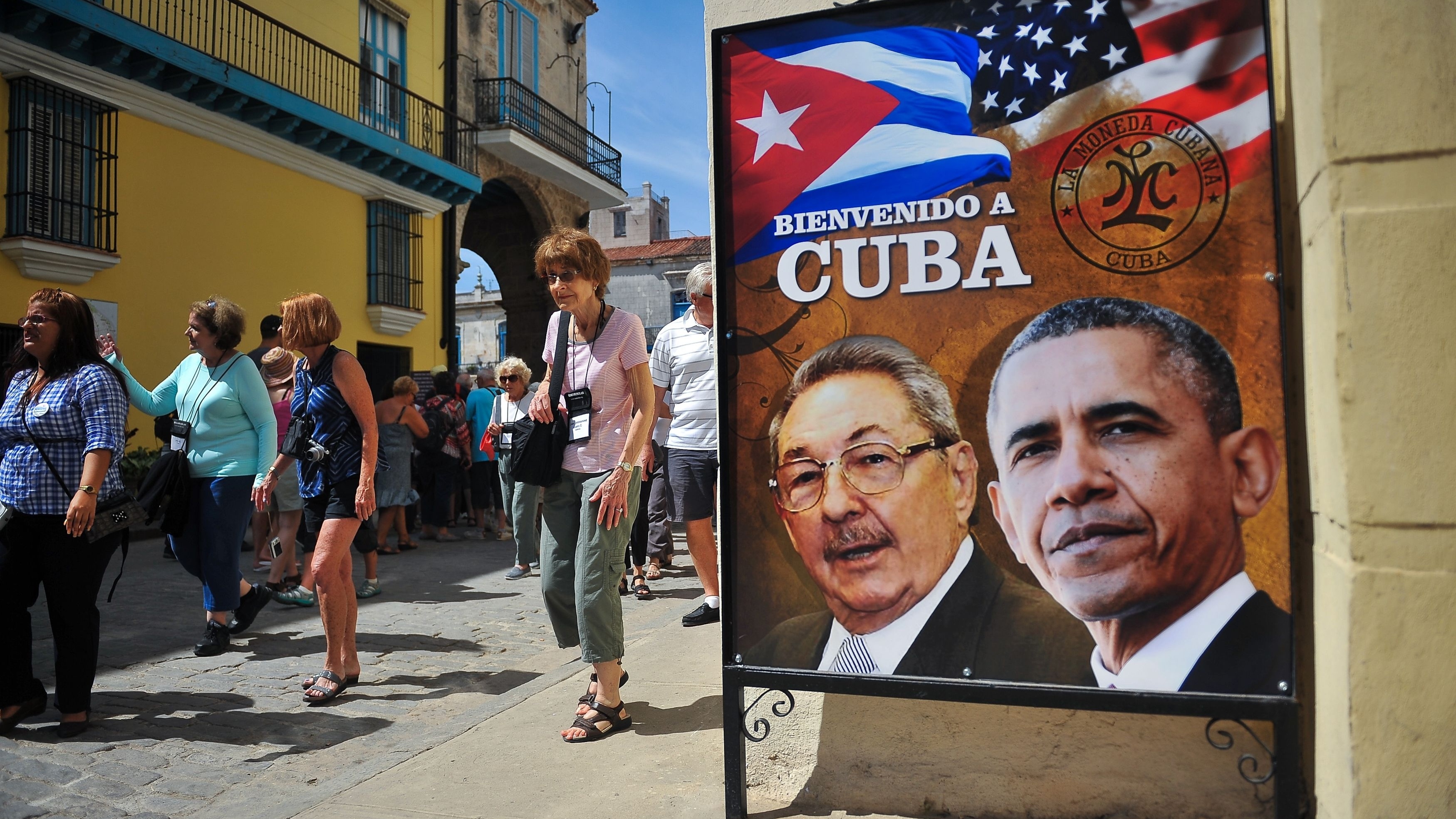 Tourists walk next to a poster of Cuban President Raul Castro and President Obama ahead of the U.S. leader's visit. (AFP/Getty Images)