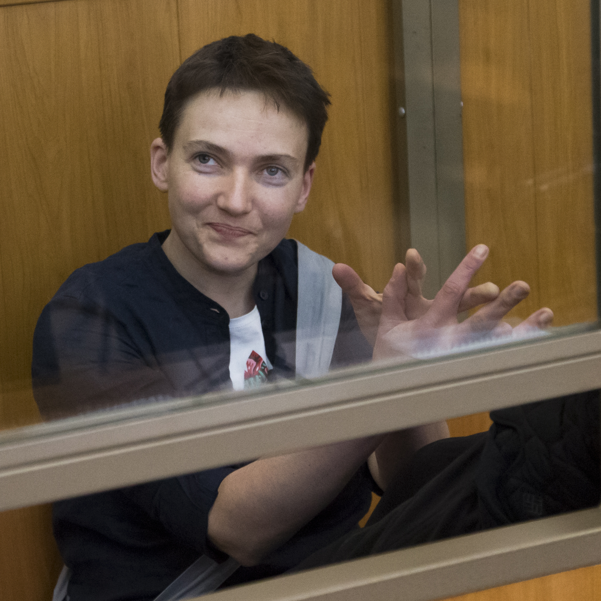Ukrainian pilot Nadezhda Savchenko applauds and smiles in a glass cage inside court ahead of the verdict in the town of Donetsk, Rostov-on-Don region, Russia, on Tuesday.