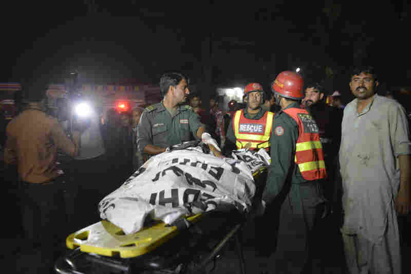 Rescuers use a stretcher to shift a body from Gulshan-e-Iqbal park on Sunday.