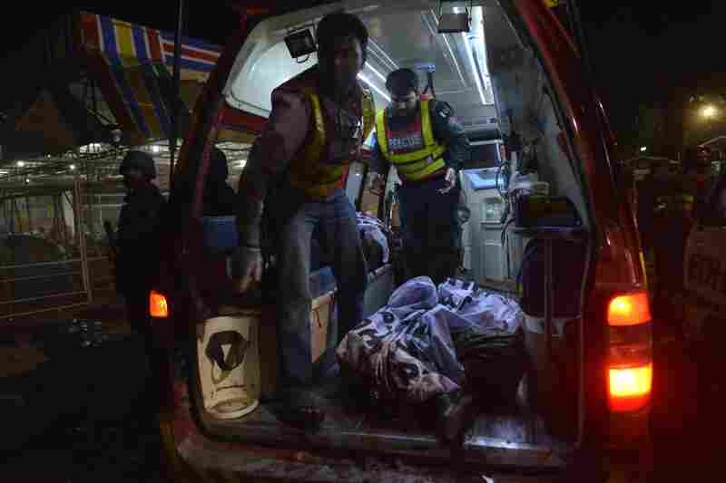 Rescuers carry a body in an ambulance from the bomb blast site.