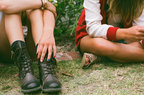 Close up low section of two girls sitting side by side