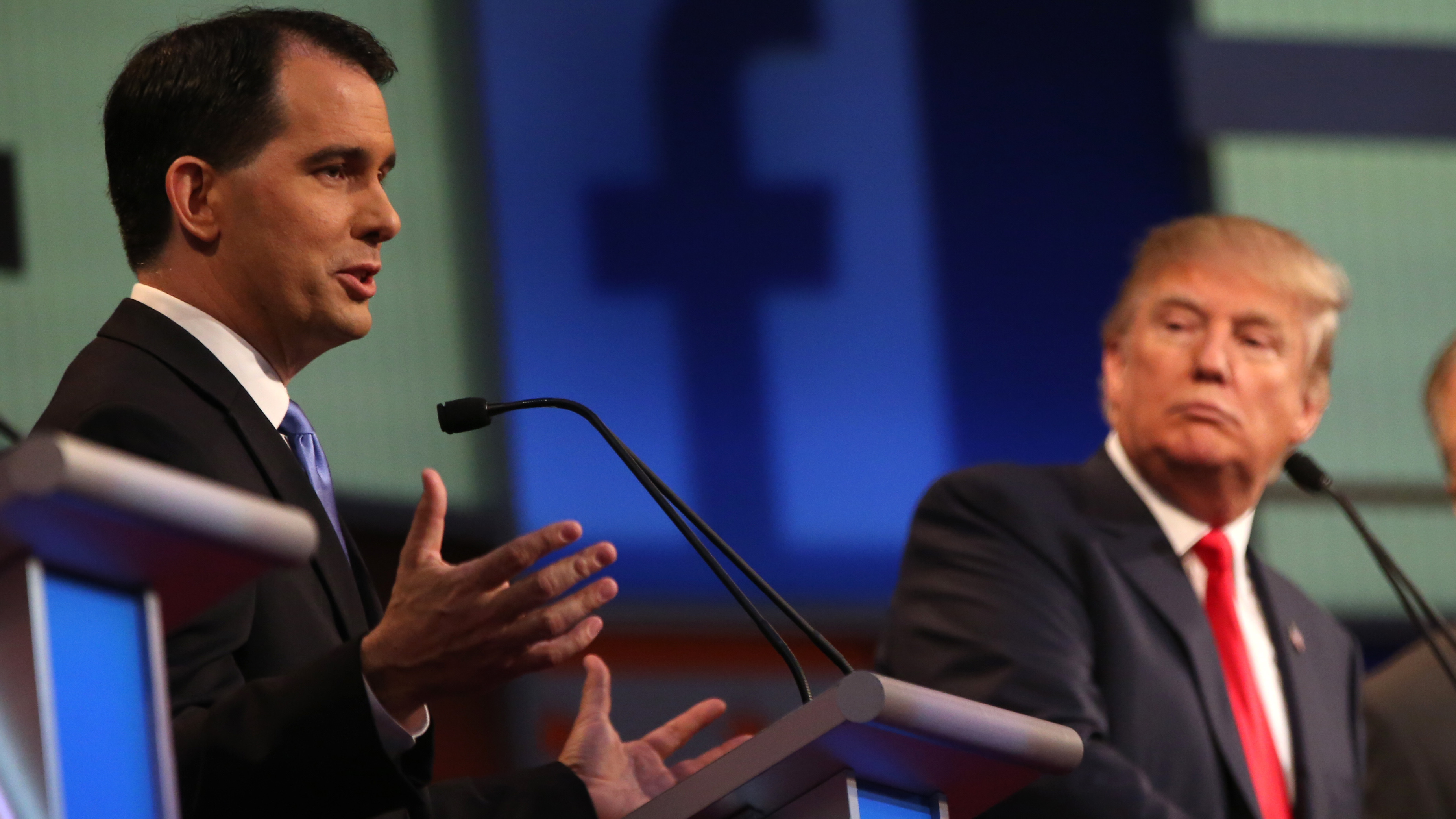 Republican presidential candidate Scott Walker speaks as Donald Trump, listens during the first Republican presidential debate in Cleveland last August.