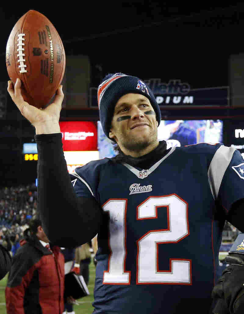 New England Patriots quarterback Tom Brady holds up the game ball after an NFL divisional playoff football game against the Baltimore Ravens in Foxborough, Mass., on Jan. 10, 2015. A week later, the team would be accused of deliberately deflating footballs in the AFC Championship game against the Indianapolis Colts.
