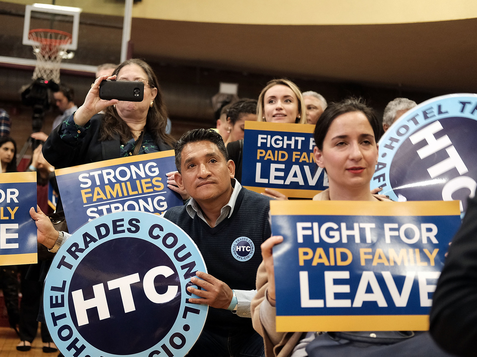 Supporters watch as New York Gov. Andrew Cuomo speaks to promote his paid family leave initiative at a rally in Manhattan on March 10. (Spencer Platt/Getty Images)