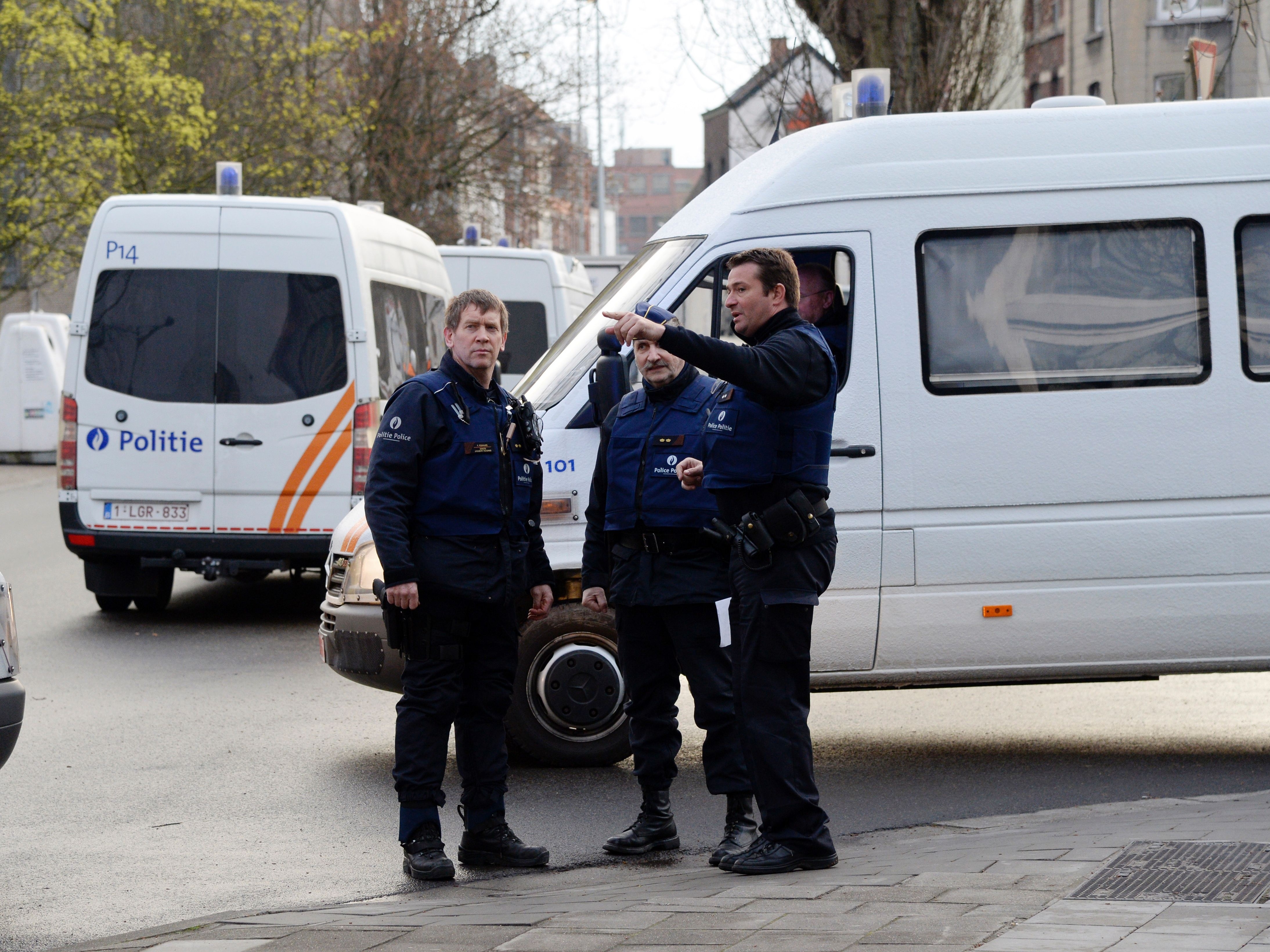 Belgian police officers stand in Albert I square in Brussels, where authorities arrested Mohamed Abrini, a key Paris attacks suspect, on Friday.