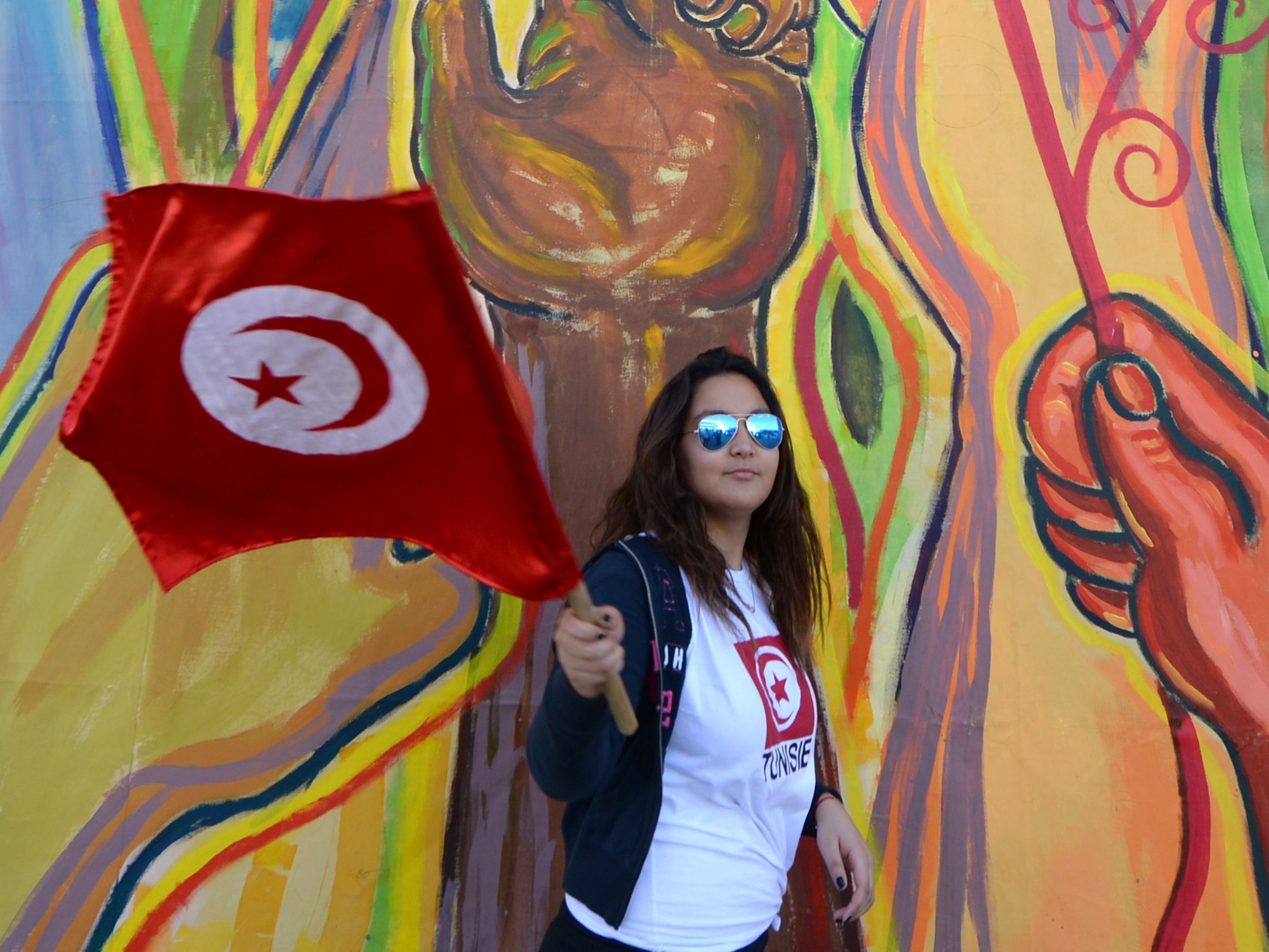 A Tunisian woman waves her national flag as international activists gather for the World Social Forum in Tunis on March 25, 2015.