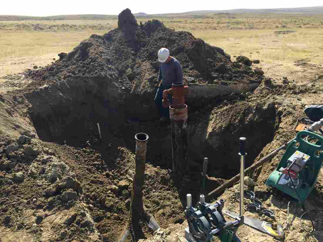 A contractor prepares to cut off the top of a coal bed methane well near Gillette, Wyo., in 2015. It's one of thousands of abandoned, plugged wells sprinkled throughout Wyoming and Colorado.