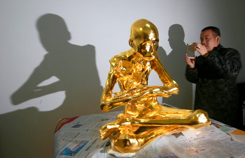 A man photographs the mummified body of revered Buddhist monk Fu Hou in March in Quanzhou city in southeastern China's Fujian province.