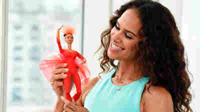 Ballerina Misty Copeland poses with the Barbie doll that's based on her, in this promotional photo released by Mattel.