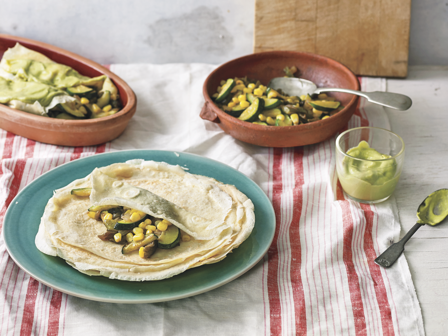 Crepes are a cousin of the enchilada, says Mexican chef Pati Jinich. A vestige of French intervention in Mexico, crepes are now considered classics of Mexican gastronomy. (Above) Jinich's crepe enchiladas with corn, poblano chiles and squash in an avocado-tomatillo sauce. (Courtesy of Houghton Mifflin Harcourt)