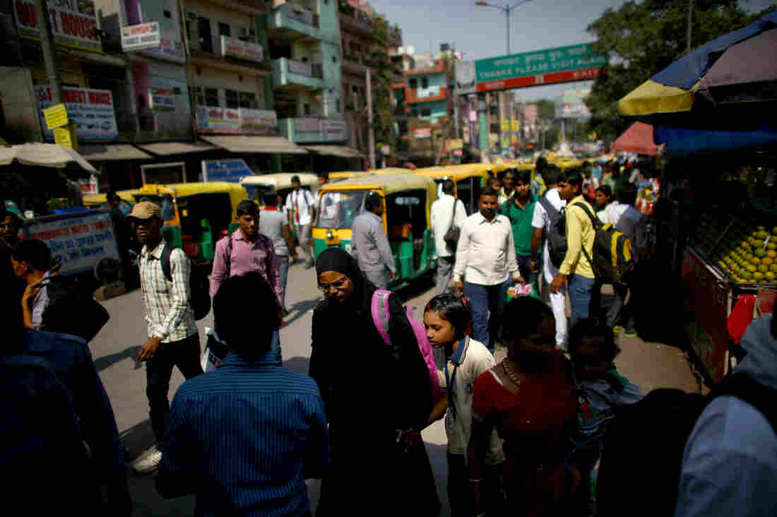 Cars, motorcycles, and rickshaws all share the crowded streets of New Delhi.