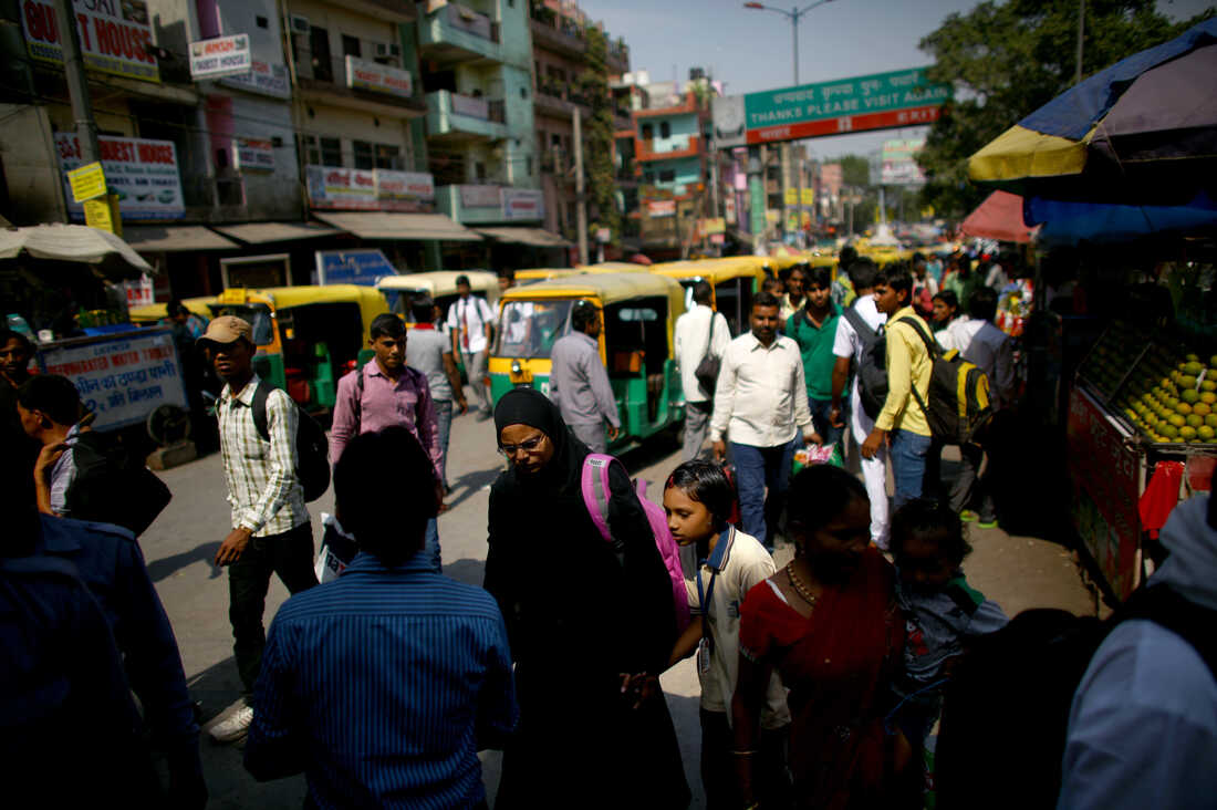 Cars, motorcycles, and rickshaws all share the crowded streets of New Delhi.