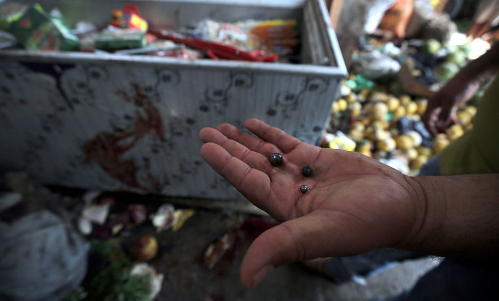 An Iraqi man displays steel pellets at the site of a suicide bombing Tuesday in the Shaab area of Baghdad.