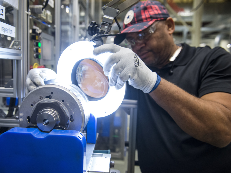 An employee inspects a component for hybrid electric vehicle motors at the Toshiba International Corp. manufacturing facility in Houston. (Bloomberg/Bloomberg via Getty Images)