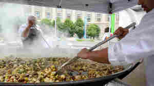 Chefs cook vegetables that will be added to a giant, 7-foot-wide platter of paella. The dish, made from produce diverted from the dump, was served up as part of a free feast for 5,000 in Washington, D.C., Wednesday to raise awareness about food waste.