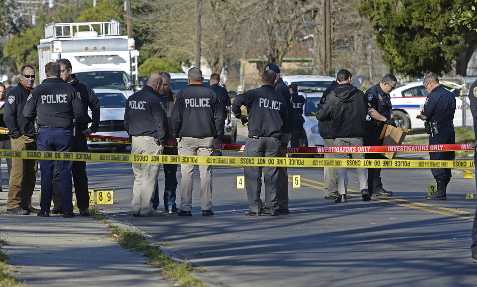 Officers investigate the scene of a shooting in Baton Rouge, La., in February. (Bill Feig/AP)