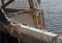 Na'alehu Anthony's hand rests over a small black mark on the rail of the boat. Marks like this create a grid on the entire boat to help orient the navigator in the direction which they are heading.