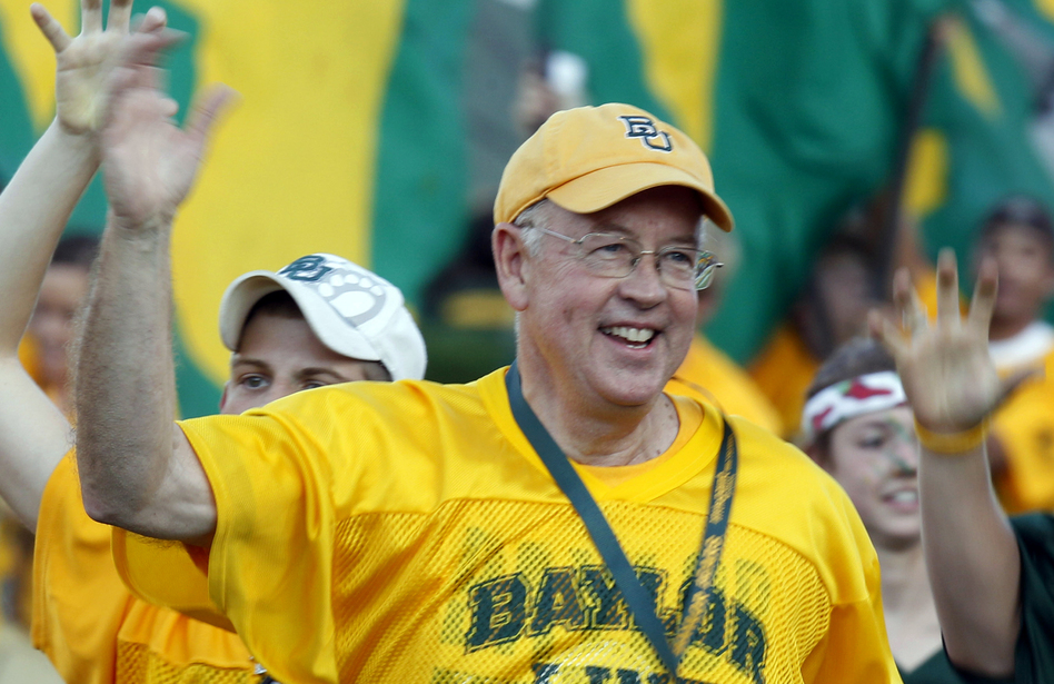 Baylor University President Kenneth Starr runs onto the football field before a 2011 game against Texas Christian University in Waco, Texas. Starr became president of Baylor in 2010. (LM Otero/AP)
