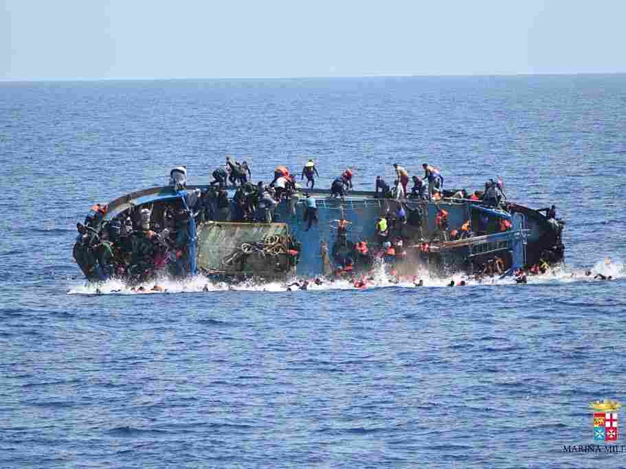 Migrants in an overcrowded boat, which was about to capsize, are rescued by Bettica and Bergamini ships of Italian Navy at Sicilian Strait, between Libya and Italy, in Mediterranean sea on Wednesday.