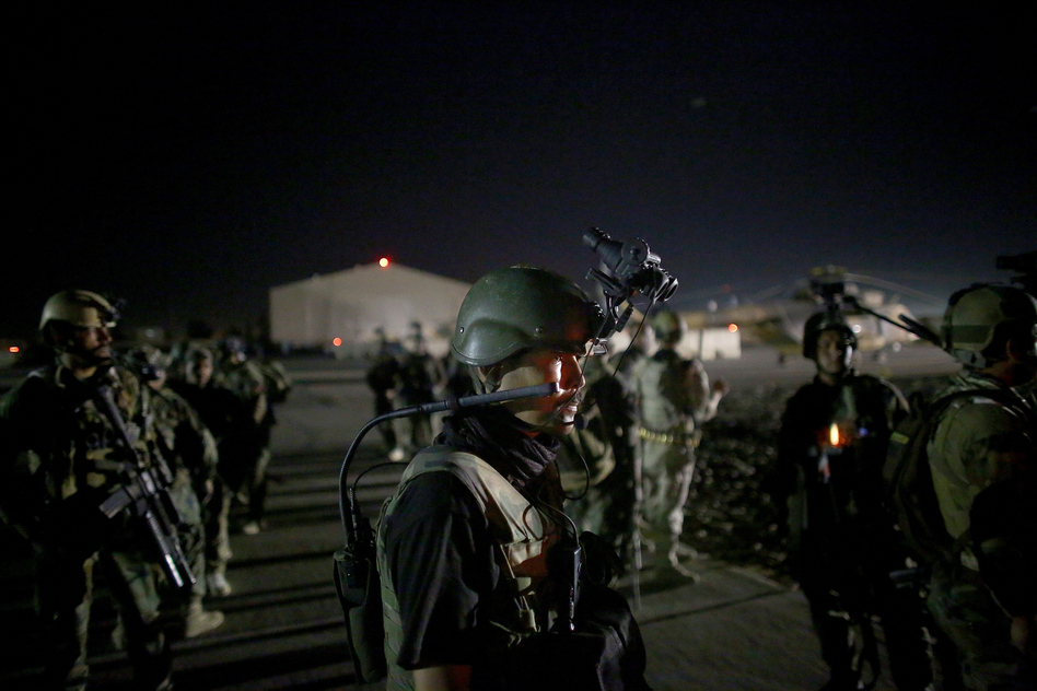 An Afghan commando stands on the tarmac, wearing night vision gear. The elite commandos are about to fly into an area controlled by Taliban fighters. Their mission: to sweep a village for Taliban fighters. (David Gilkey/NPR)