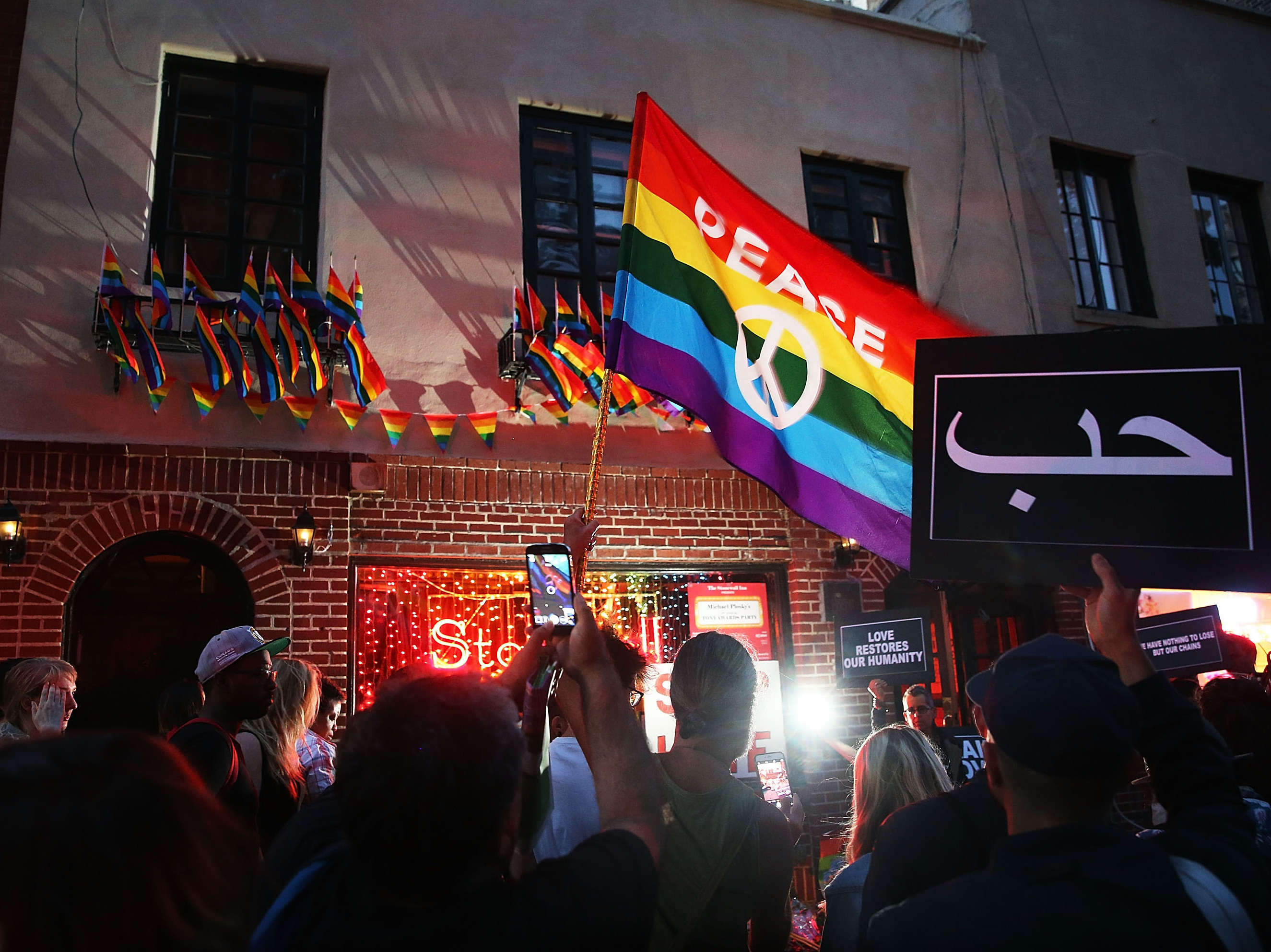Mourners gather outside of the iconic New York City gay and lesbian bar the Stonewall Inn to light candles, lay flowers and grieve for those killed in Orlando last evening on June 12, 2016. (Getty Images)