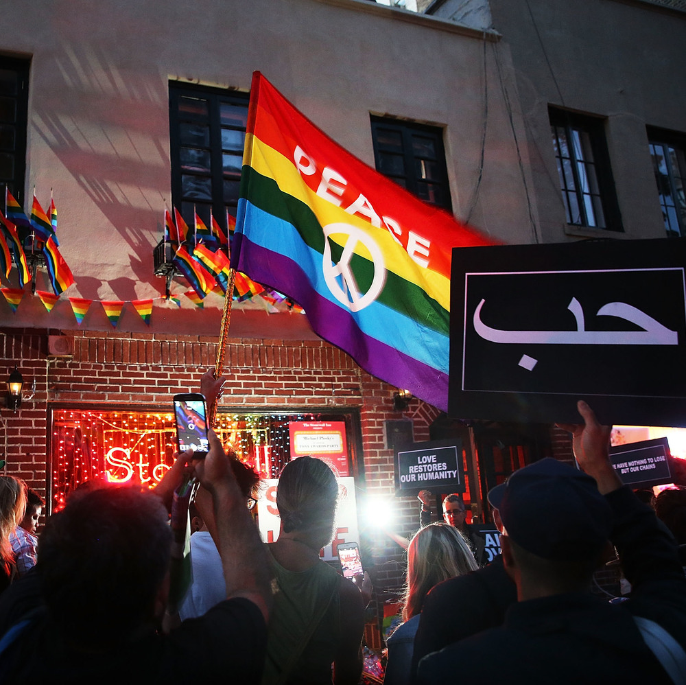 Mourners gather outside of the iconic New York City gay and lesbian bar the Stonewall Inn to light candles, lay flowers and grieve for those killed in Orlando last evening on June 12, 2016.